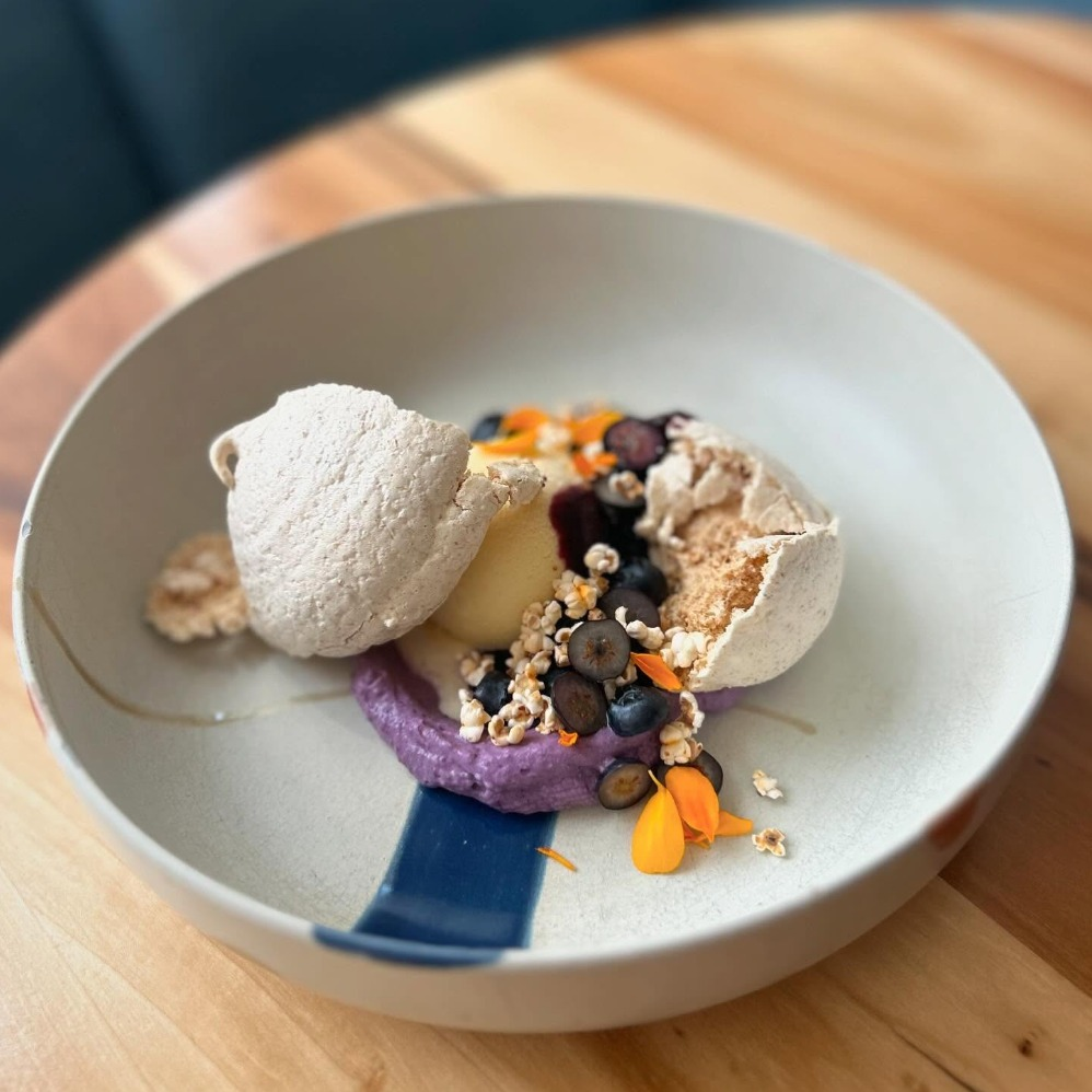 Urban Hearth dessert with meringue, fresh berries, and purple berry puree