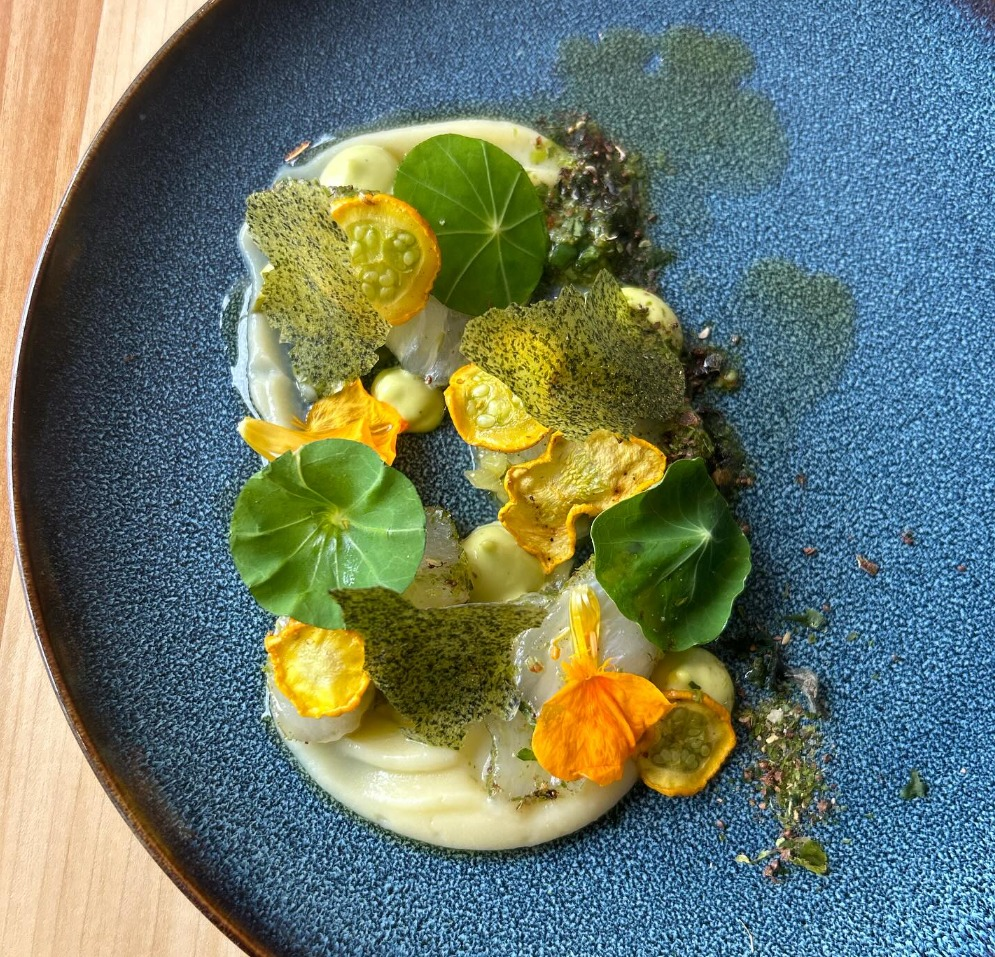 Urban Hearth scallop dish with nasturtium leaves, edible flowers, and green herb crust