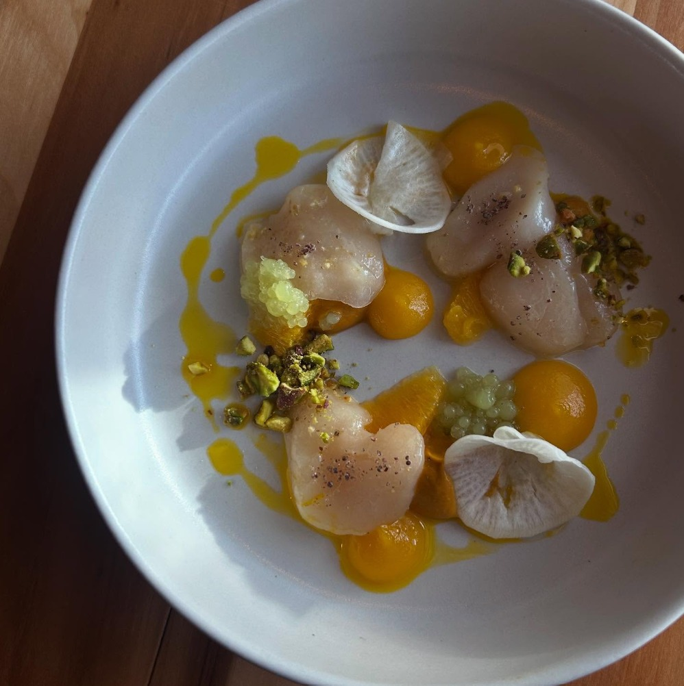 Urban Hearth scallop dish with golden egg yolk sauce, mushrooms, and pistachios