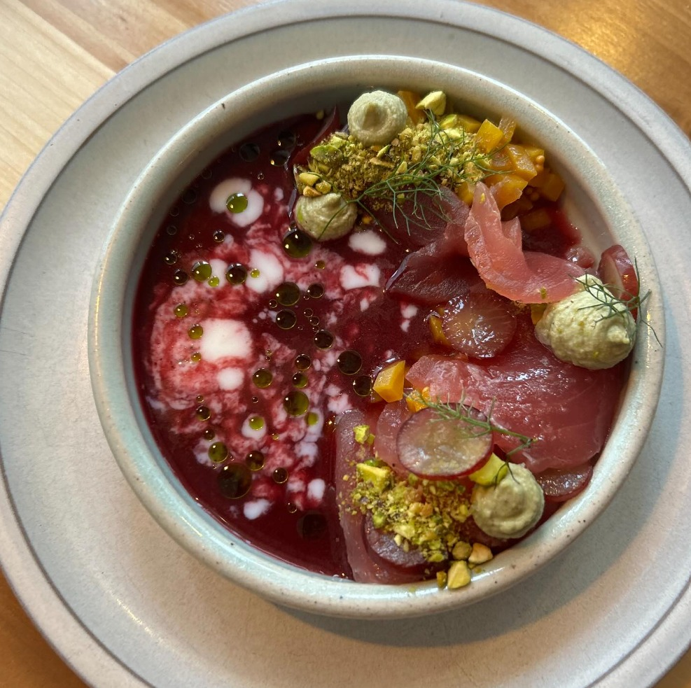 Urban Hearth tuna bowl in rich red broth with pistachio and radish garnish